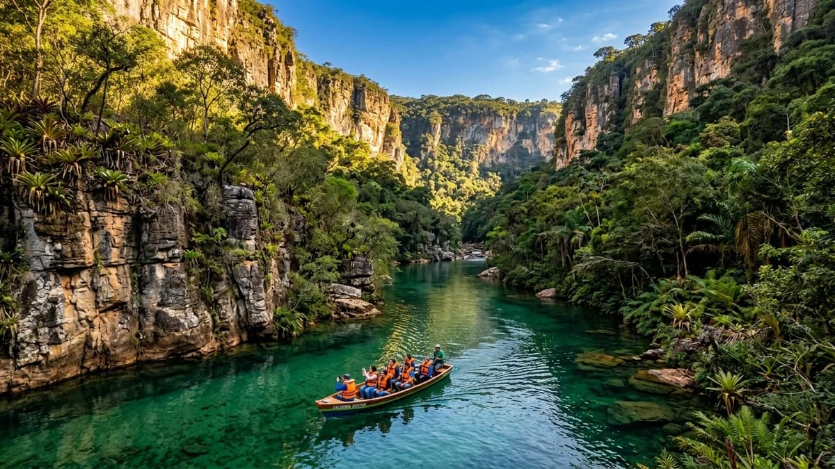 Vista espetacular do Cânion do Rio Salobra na Serra da Bodoquena em Mato Grosso do Sul com paredões verticais de rocha calcária de 100 metros e rio cristalino verde-esmeralda com barco de ecoturistas sob a luz dourada de agosto