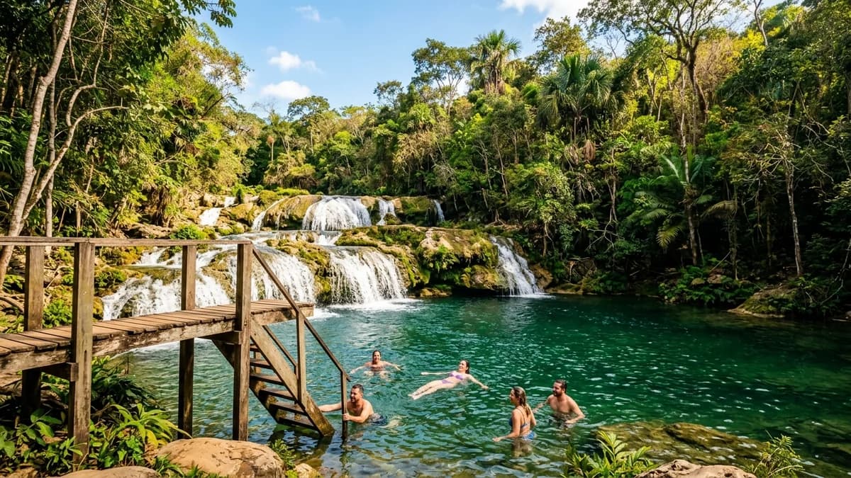 Ecoturistas nadando nas piscinas naturais verde-esmeralda das Cachoeiras da Estância Mimosa no Rio Mimoso em Bonito MS com plataforma de salto em agosto