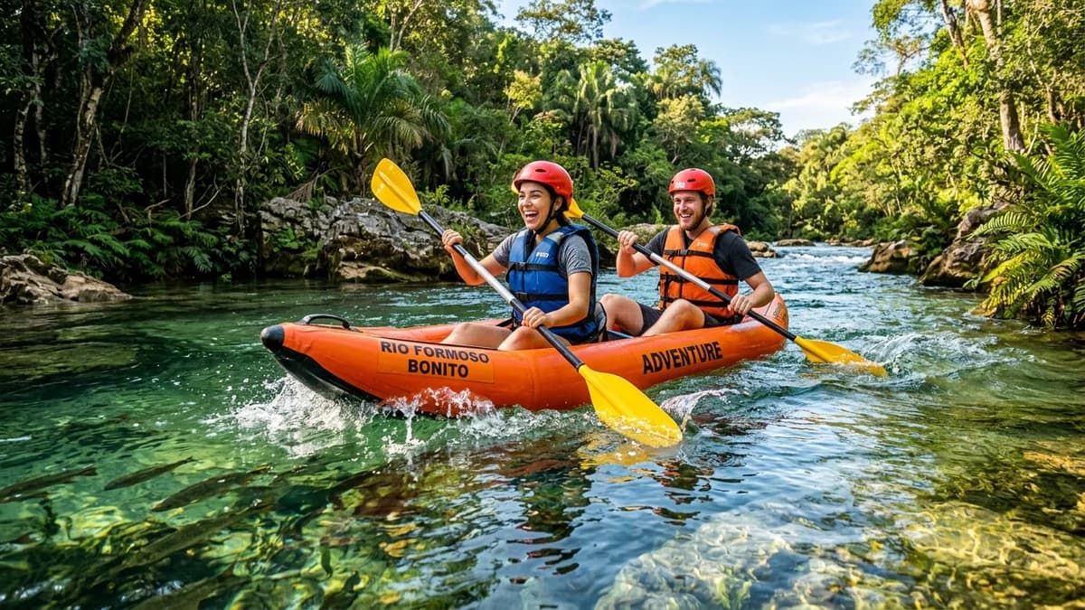 Casal sorridente remando caiaque inflável biplace Duck descendo corredeira de águas cristalinas verde-esmeralda no Rio Formoso em Bonito MS em agosto
