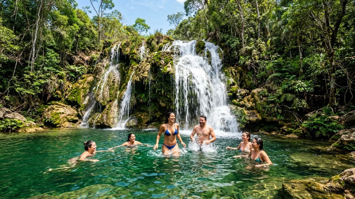 Banhistas desfrutando de piscina natural cristalina sob cachoeira de tuva calcária na Estância Mimosa em Bonito MS em setembro